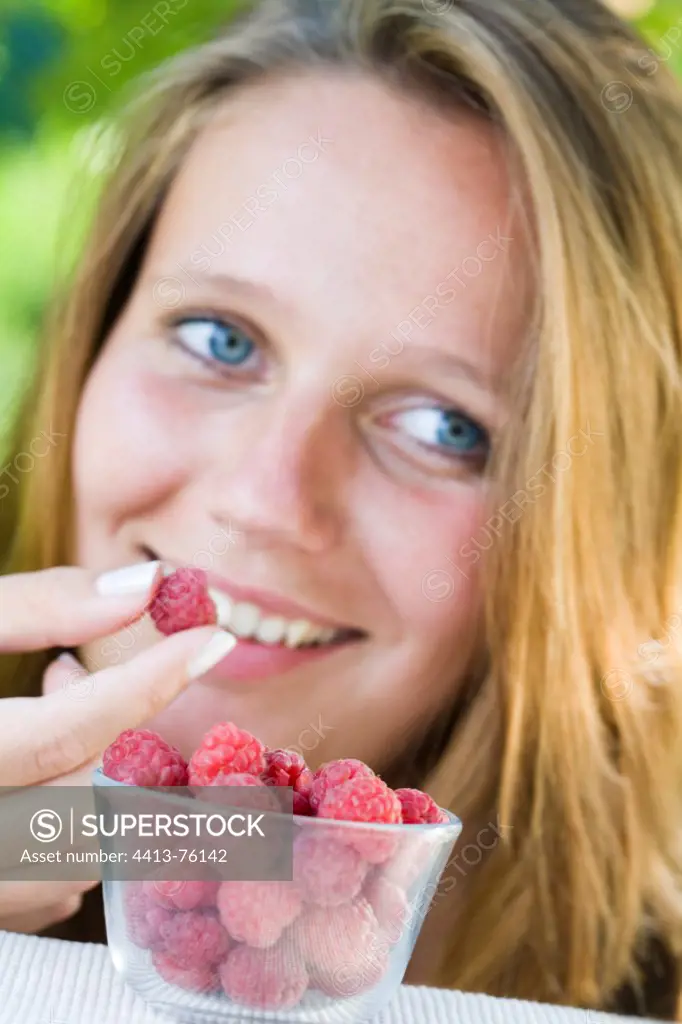 Young woman and Raspberries in a pot in the garden France