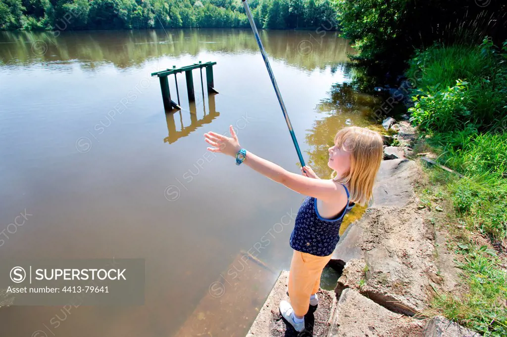 A girl in the angling pond in summer