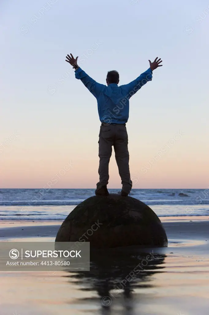 Man standing on Moeraki Boulder South Island New Zealand