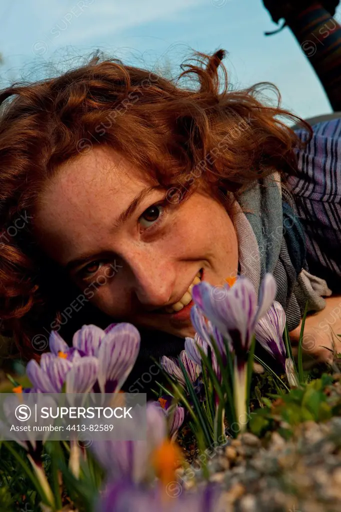 Young girl lying down in a garden with crocus