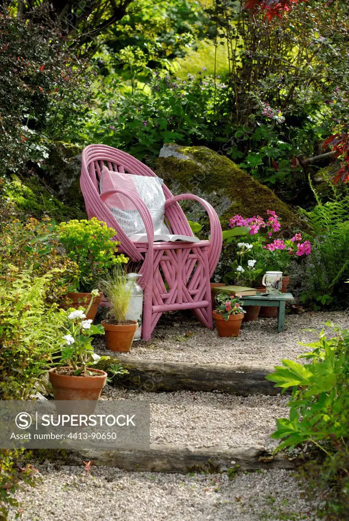 Rattan armchair in a flowered garden