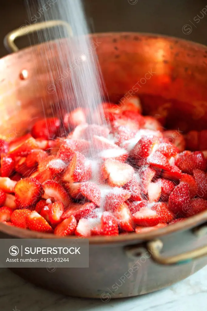 Strawberries and sugar in a preserving pan copper