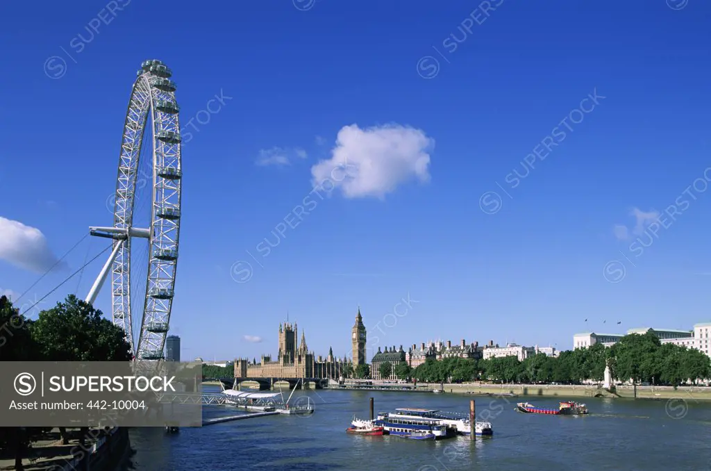 Low angle view of a ferris wheel near a river, London Eye, London, England