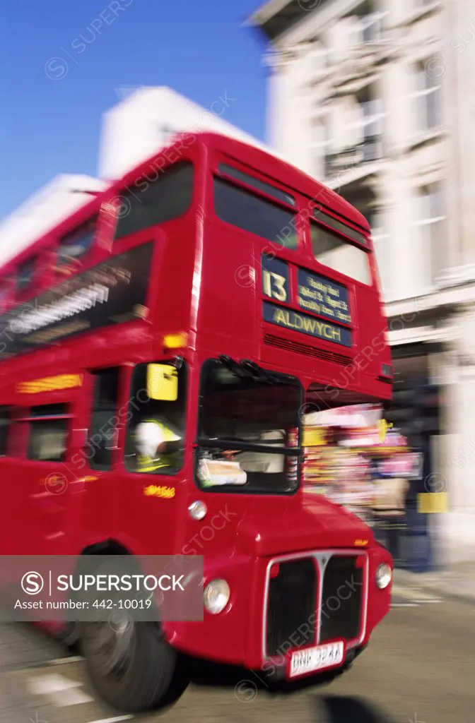 Low angle view of a double-decker bus moving on a road, London, England