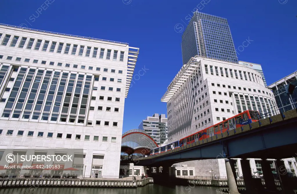 Low angle view of a passenger train on a bridge across a river, Docklands Light Railway, Canary Wharf, Docklands, London, England