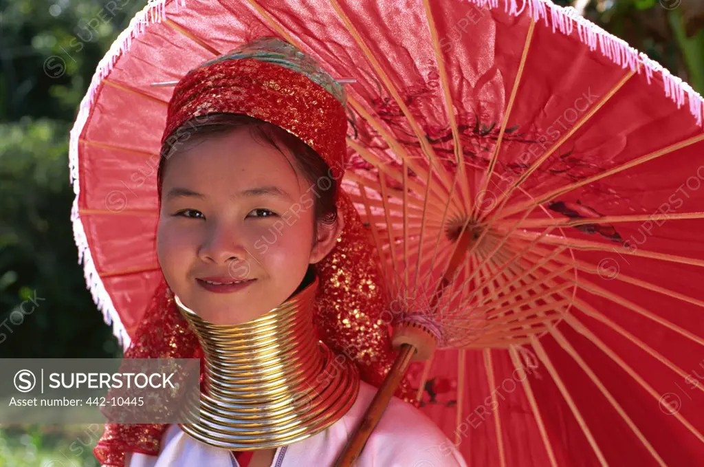 Portrait of a Karen tribal teenage girl holding a parasol and smiling, Chiang Rai, Chiang Rai Province, Thailand