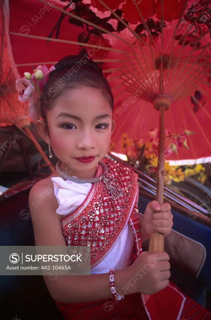 Portrait of a girl in traditional Thai costume holding a parasol at a traditional festival, Chiang Mai Flower Festival, Chiang Mai, Chiang Mai Province, Thailand