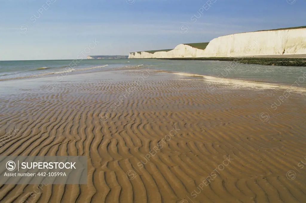 Rippled pattern on sand with limestone cliff in the background, Seven Sisters, Beachy Head, Eastbourne, East Sussex, England