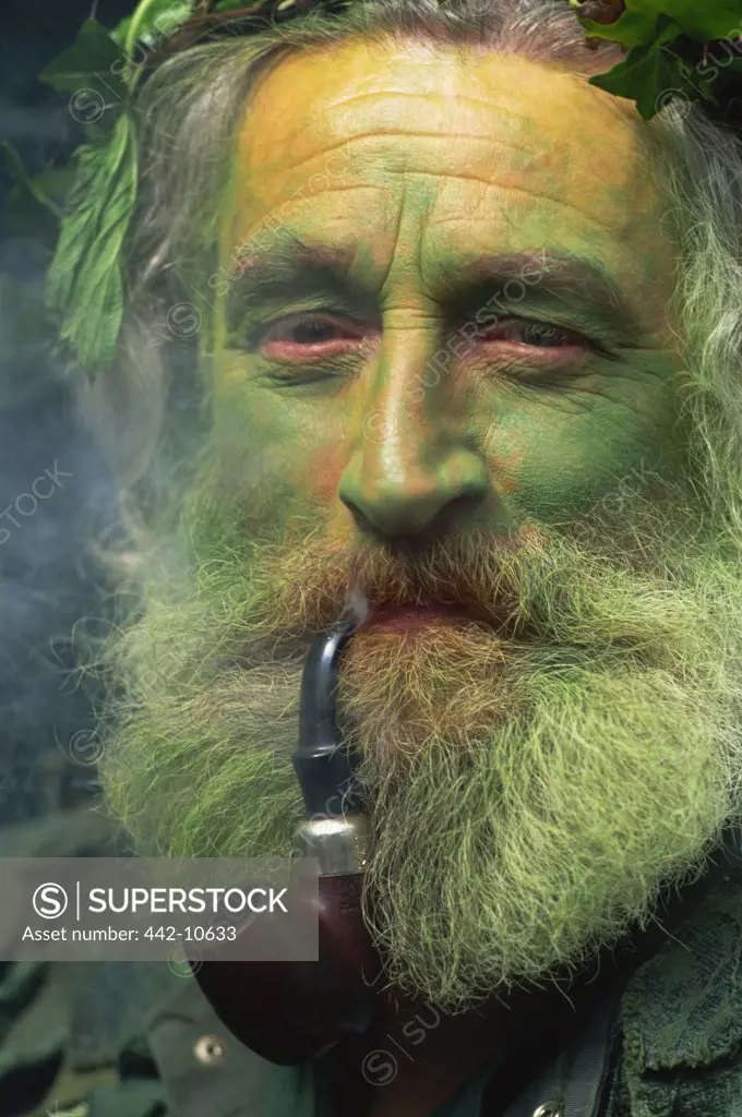Portrait of a Jack in the Green attendant smoking a pipe, Rochester, Kent, England