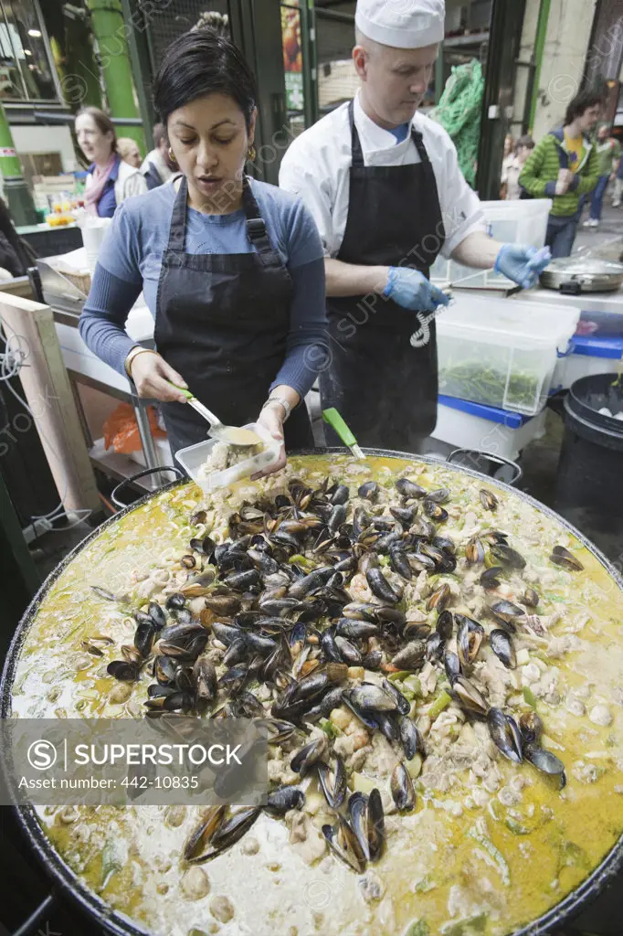 England, London, Southwark, Borough Market, Chef Cooking Curried Mussels