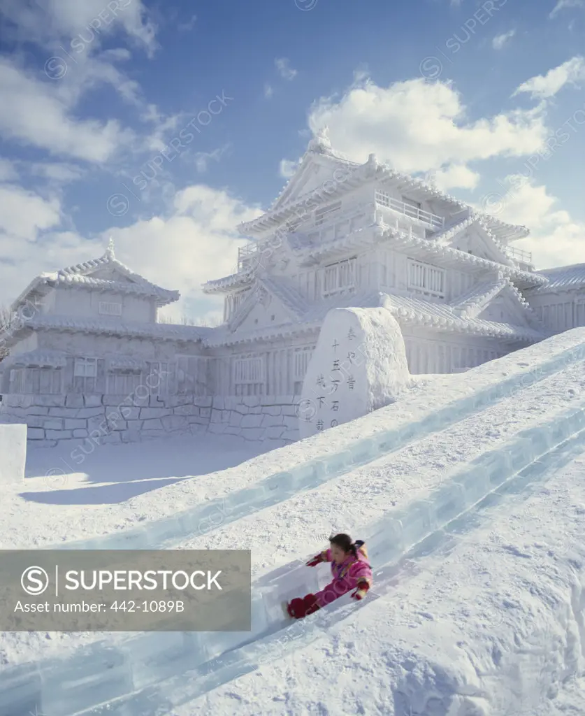 Child sliding down a slope, Snow Festival, Sapporo, Hokkaido, Japan