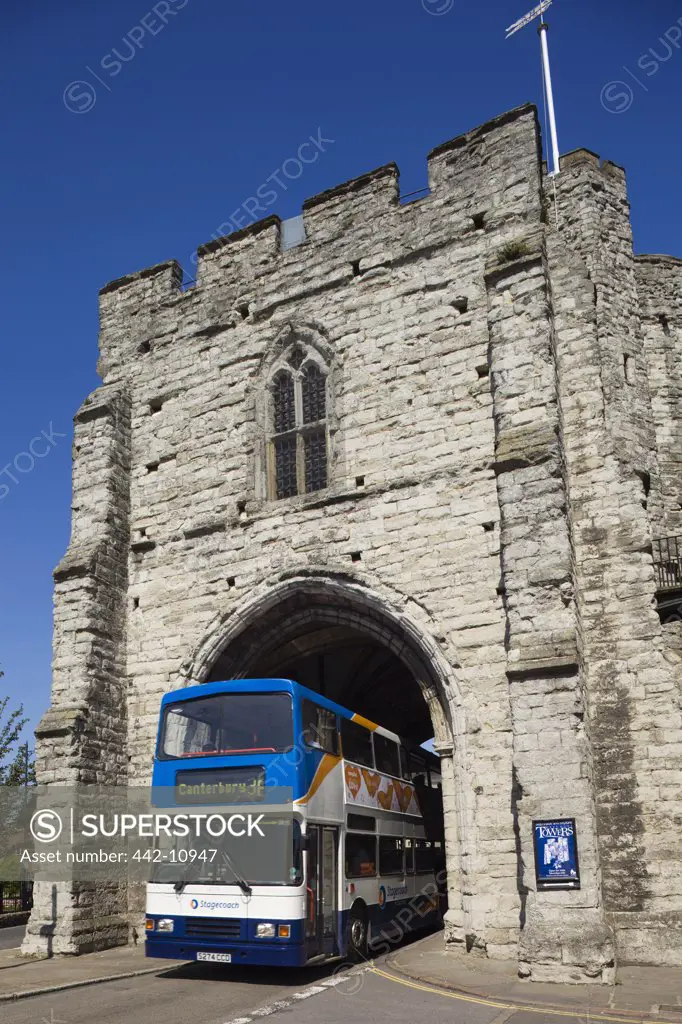 Double-decker bus passing through an archway, Westgate, Canterbury, Kent, England