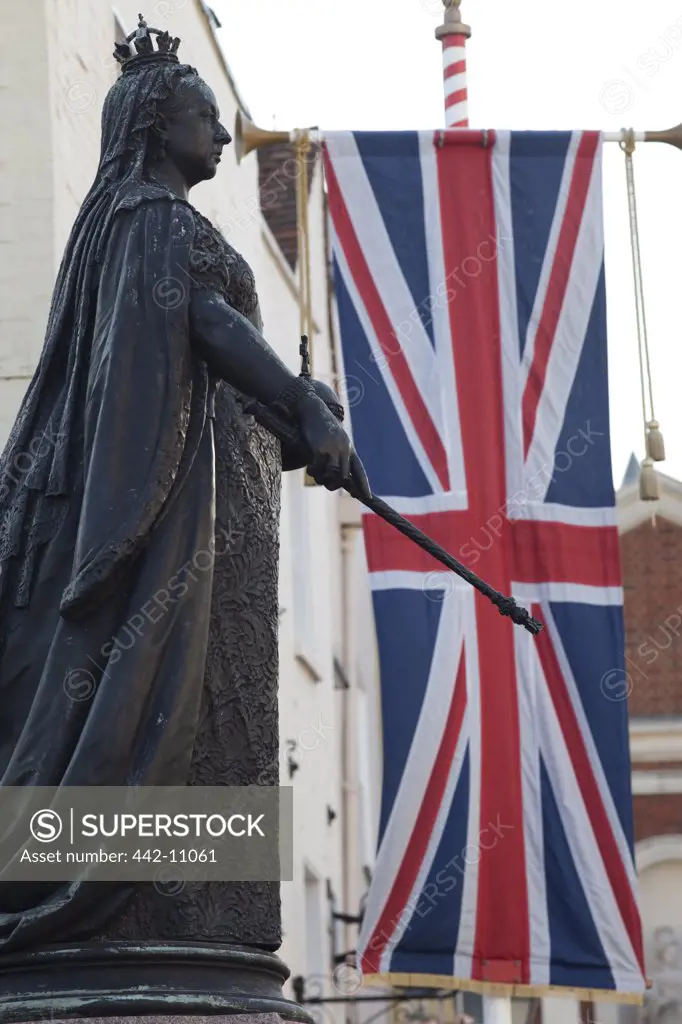 Low angle view of a Statue of Queen Victoria near the British flag, Windsor Castle, Windsor and Eton, Berkshire, England