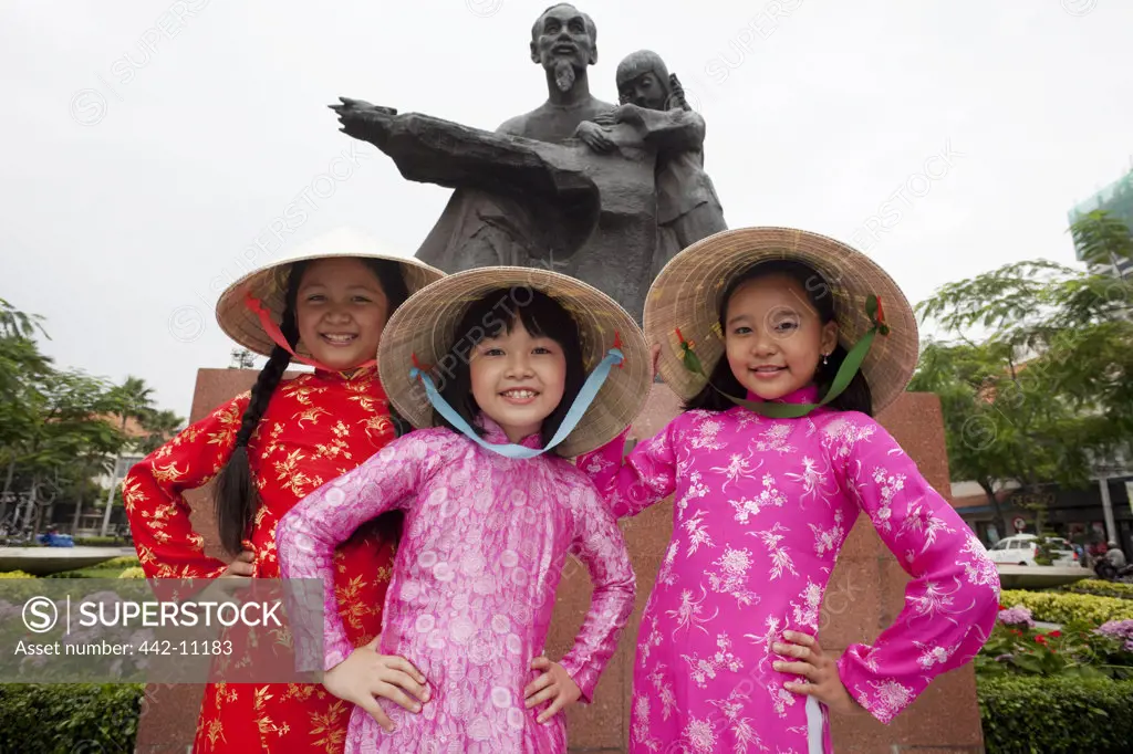 Girls posing in front of a statue, Ho Chi Minh City, Vietnam