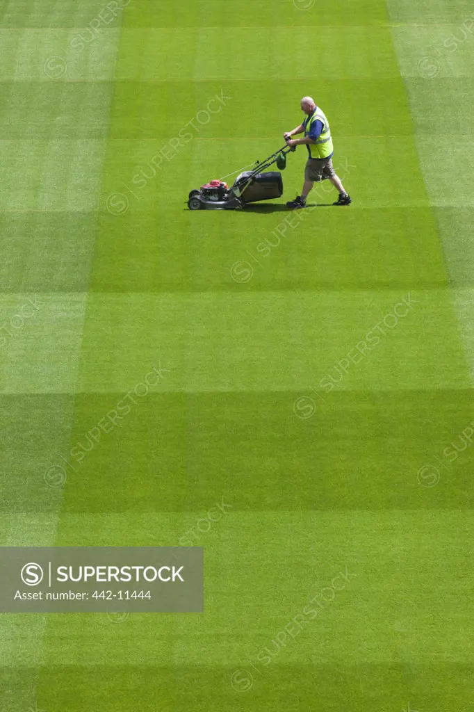 Ireland, Dublin, Greenkeeper Mowing Playing Field in The Aviva Stadium