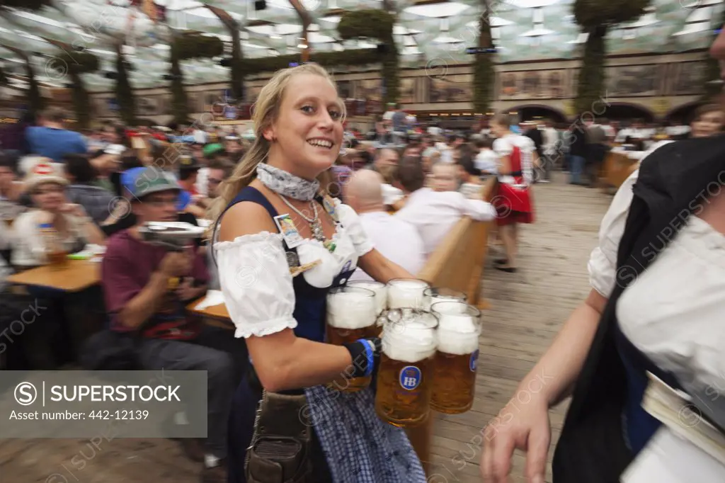 Female waitress with beer steins during Oktoberfest festival, Munich, Bavaria, Germany
