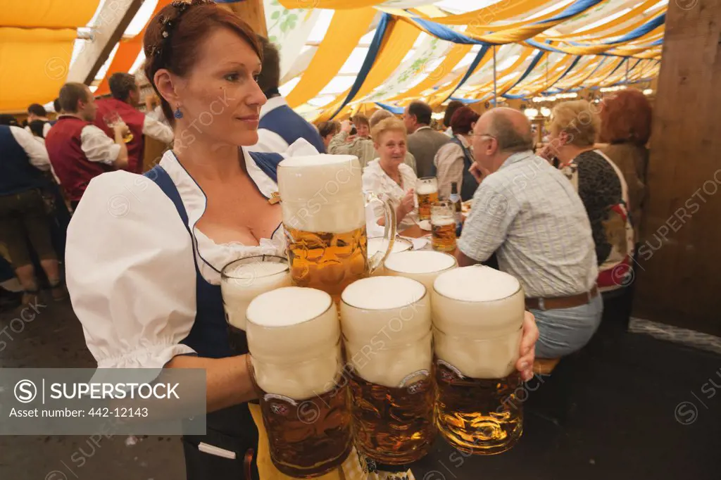 Female waitress with beer steins during Oktoberfest festival, Munich, Bavaria, Germany