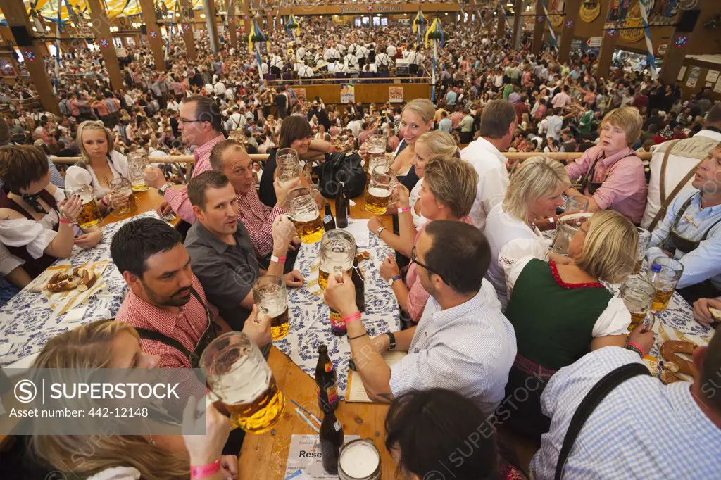 Tourists enjoying beer during Oktoberfest festival, Munich, Bavaria, Germany