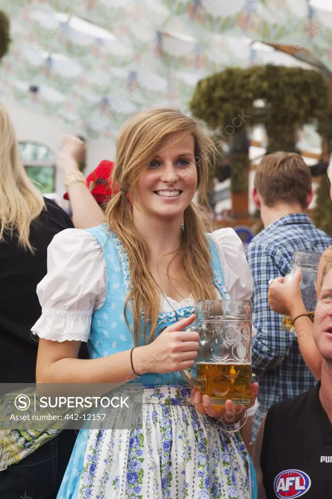 Young woman holding a beer stein, Oktoberfest, Munich, Bavaria, Germany