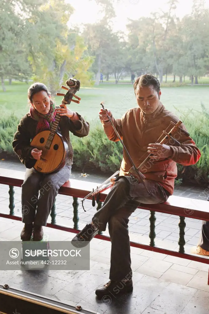 Man with a woman playing traditional Chinese stringed instruments, Temple Of Heaven, Beijing, China