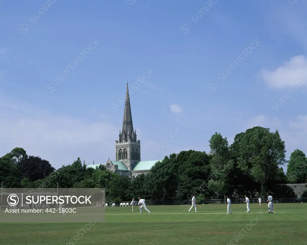 Group of people playing cricket in a field, Chichester Cathedral, Chichester, Sussex, England