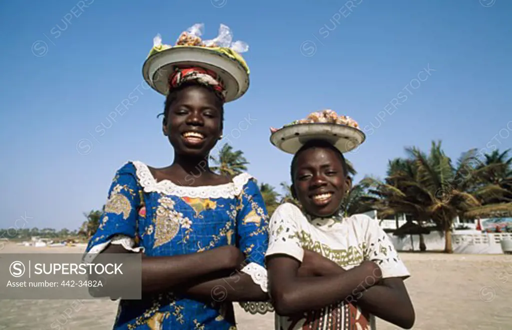 Two sisters standing side by side on the beach, Banjul, Gambia
