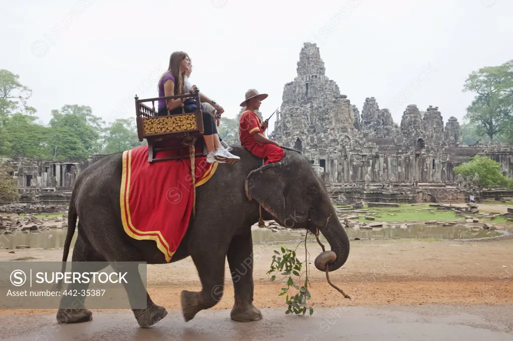 Tourists riding on an elephant, Bayon Temple, Angkor Thom, Angkor, Siem Reap, Cambodia