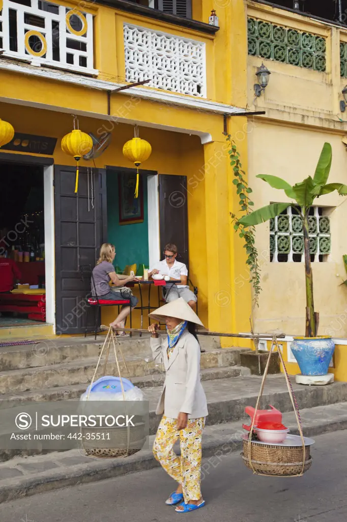 Woman selling goods in a street, Hoi An, Vietnam