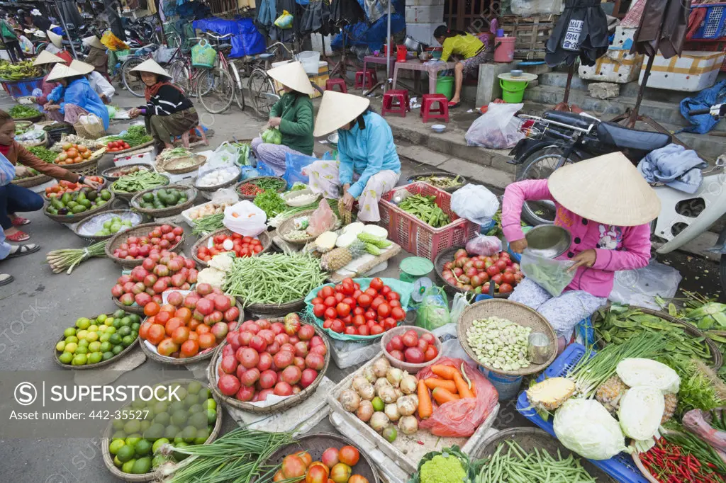 Market vendors selling vegetables at a market, Hoi An, Vietnam