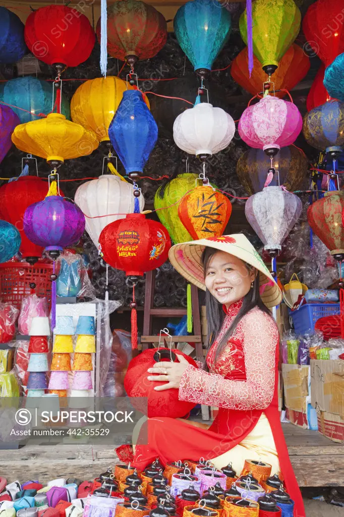 Teenage girl making paper lanterns at a market stall, Hoi An, Vietnam