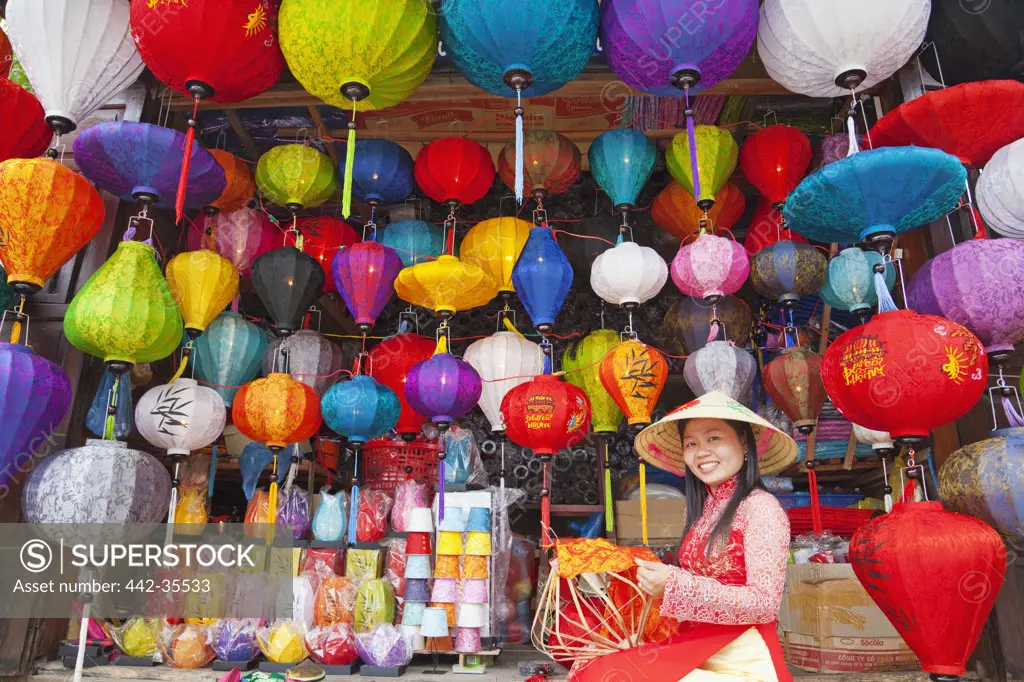 Teenage girl making paper lanterns at a market stall, Hoi An, Vietnam