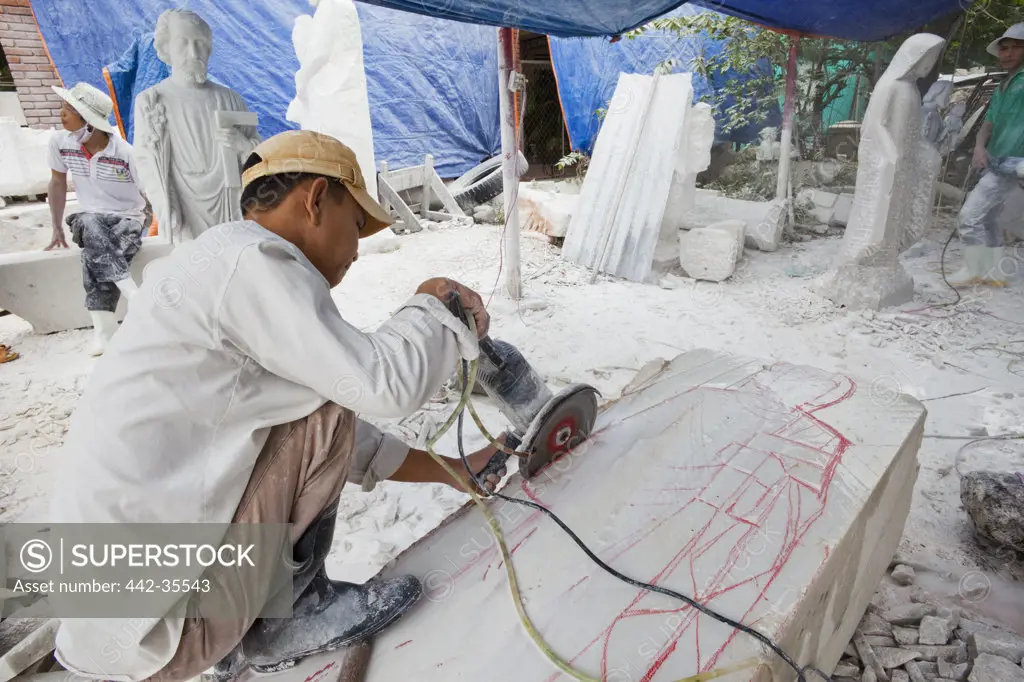 Worker cutting a marble block, Marble Mountain, Danang, Vietnam