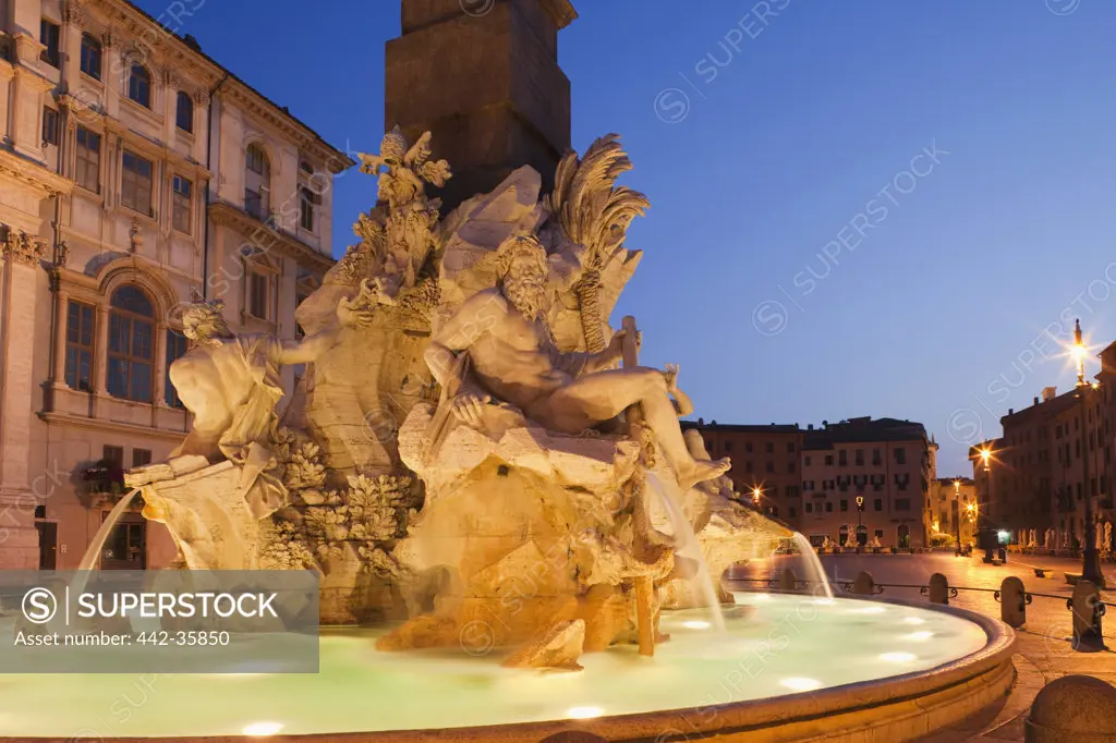 Italy, Rome, Fountain of the Four Rivers illuminated at dusk