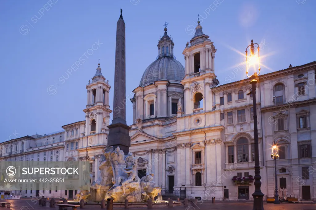 Italy, Rome, Sant'Agnese in Agone and Fountain of the Four Rivers illuminated at dusk