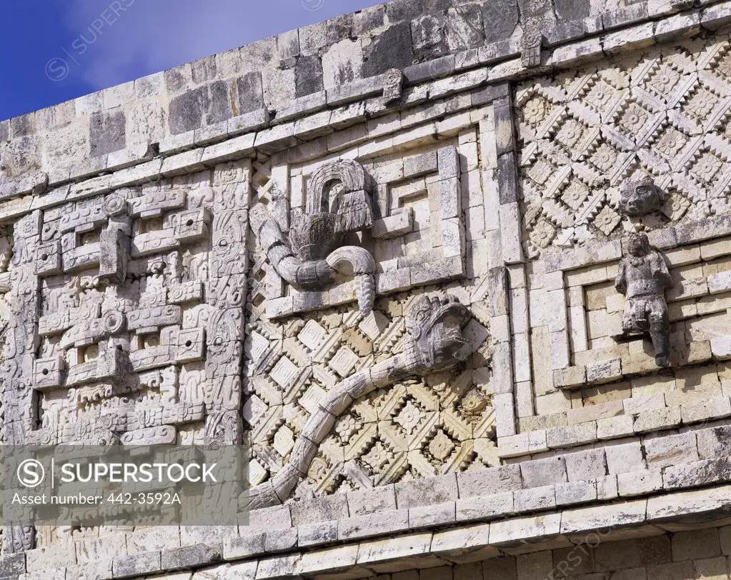 Low angle view of sculptures on a stone wall, Nunnery Quadrangle, Uxmal (Mayan), Yucatan, Mexico