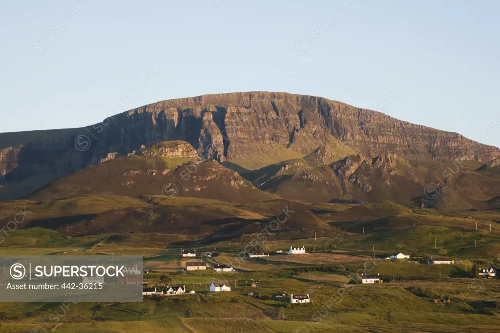 Field with mountain range in the background, Quiraing Mountain Range, Isle of Skye, Inner Hebrides, Scotland