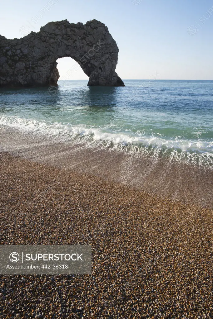 Pebbles with natural limestone arch on the beach, Durdle Door Beach, Jurassic Coast, Dorset, England