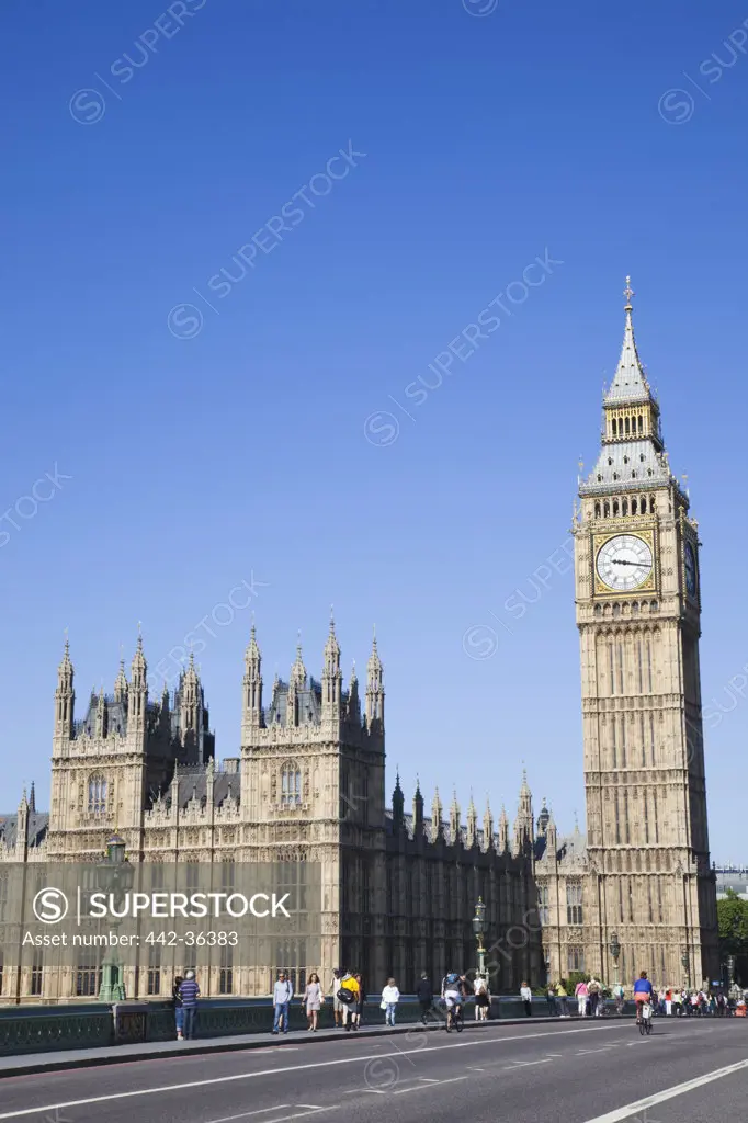 Tourists on road in front of parliament building and a clock tower, Big Ben, Houses Of Parliament, City Of Westminster, London, England