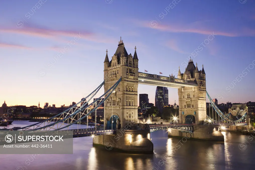 Tower Bridge lit up at dusk, Thames River, London, England