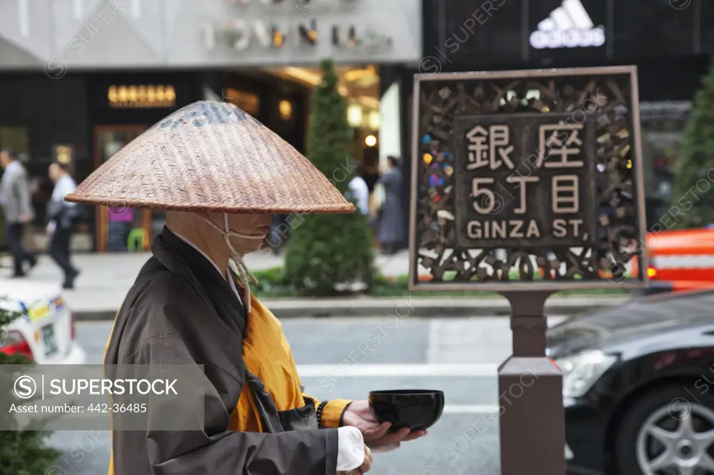 Monk collecting alms in a street, Ginza, Tokyo, Japan
