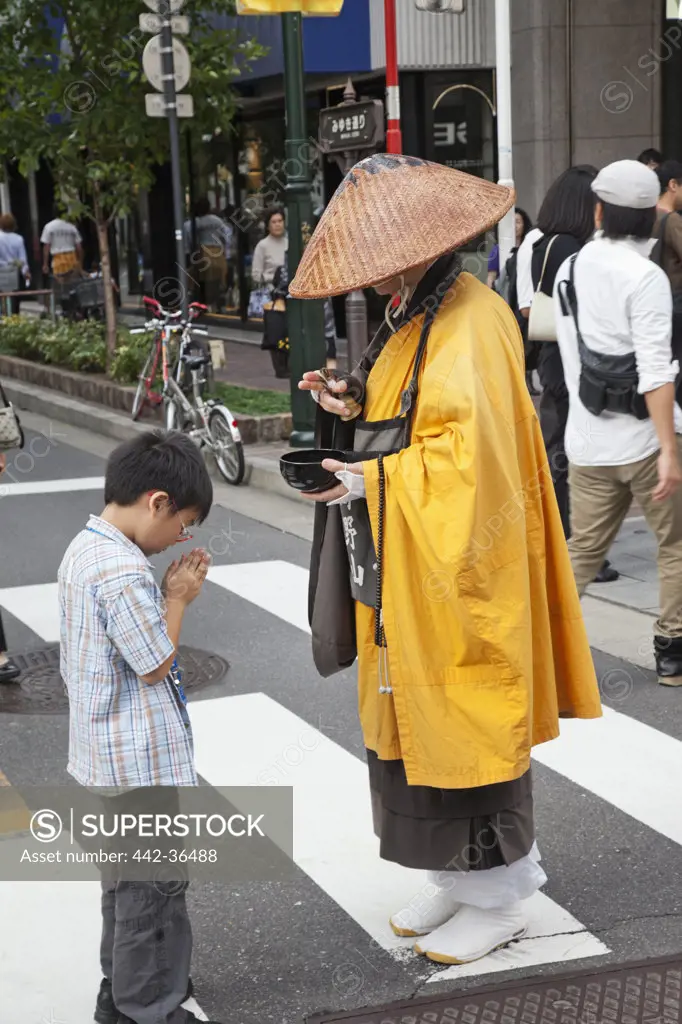 Monk blessing a boy on the road, Ginza, Tokyo, Japan