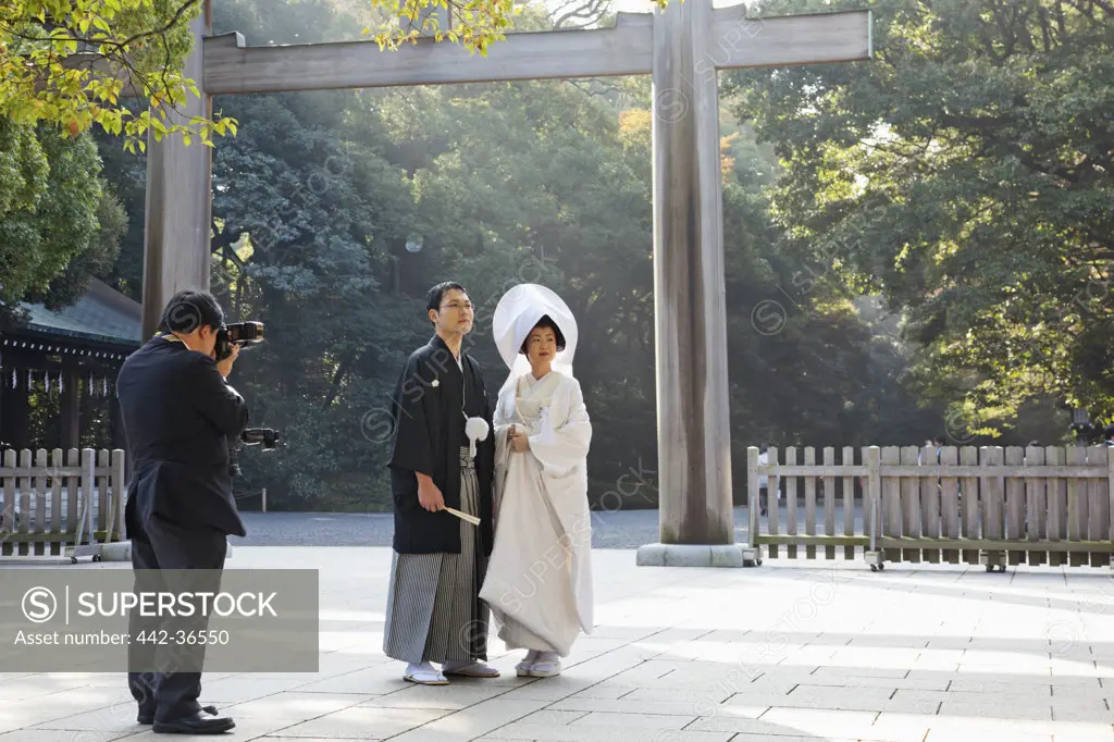Photographer taking a picture of a wedding couple at a shrine, Meiji-jingu Shrine, Shibuya Ward, Tokyo, Japan