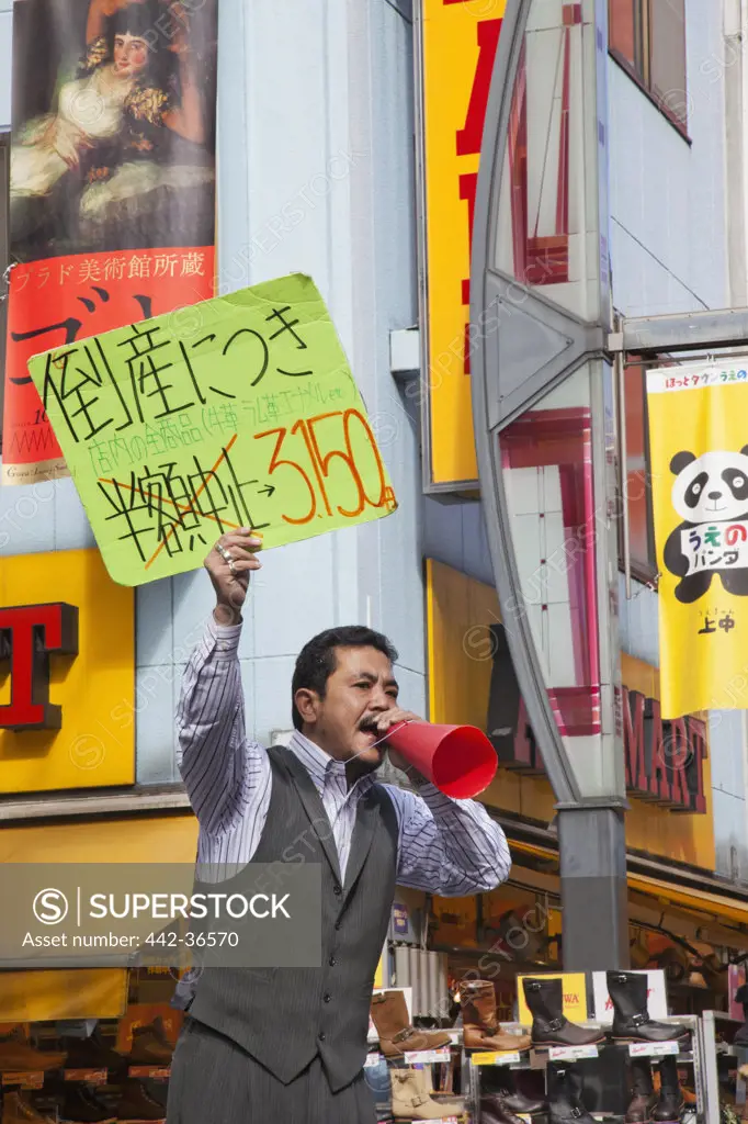 Salesman holding advertising placard, Ameya Yokocho, Ueno, Tokyo, Japan