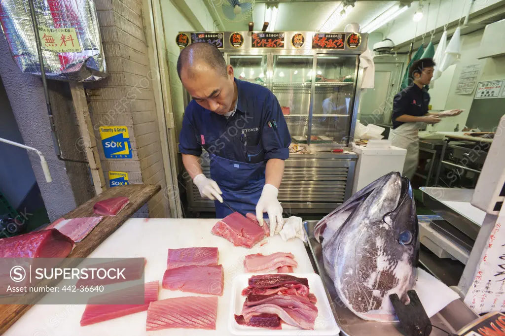 Fishmonger slicing tuna, Tsukiji Fish Market, Tokyo, Japan