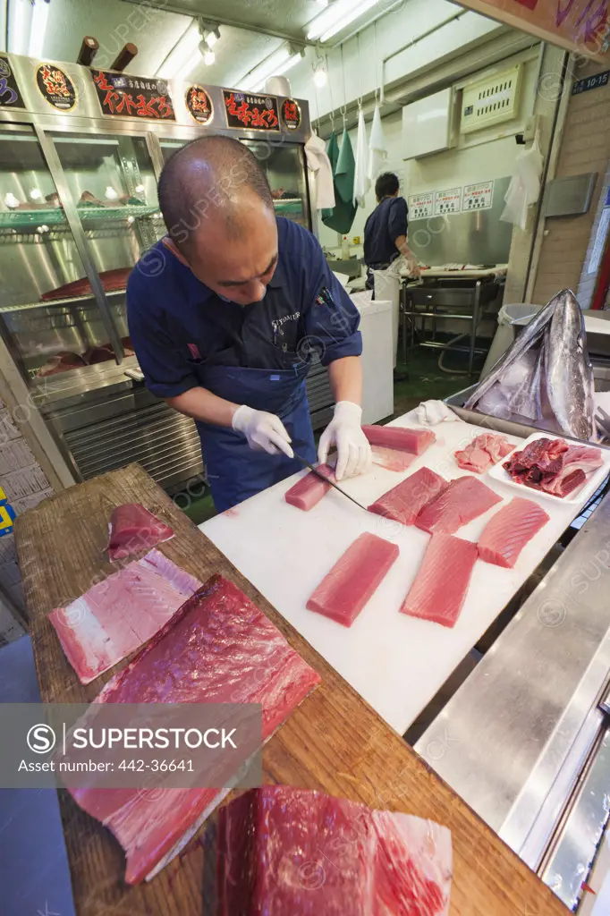Fishmonger slicing tuna, Tsukiji Fish Market, Tokyo, Japan