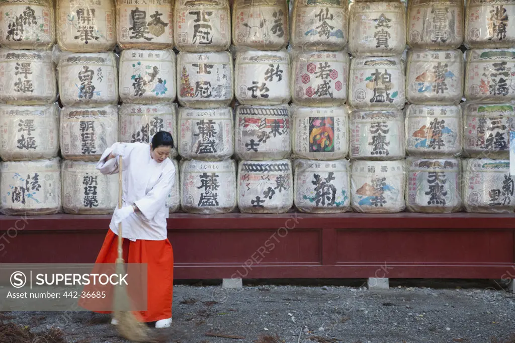 Temple helper sweeping shrine ground, Futarasan Shrine, Nikko, Honshu, Japan