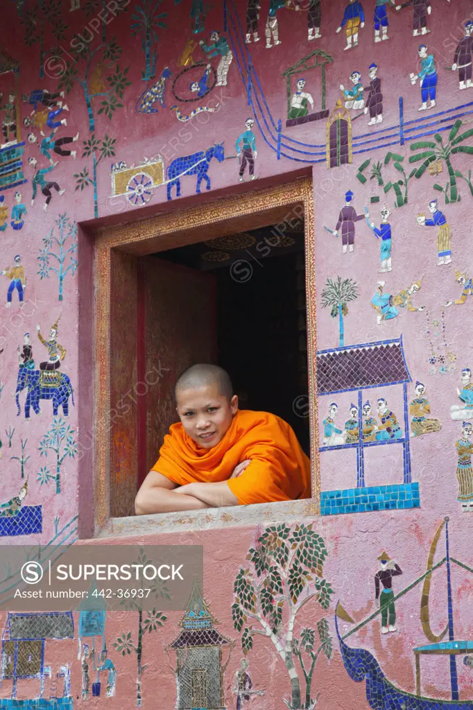 Monk at window of the Reclining Buddha Sanctuary, Wat Xieng Thong, Luang Phabang, Laos