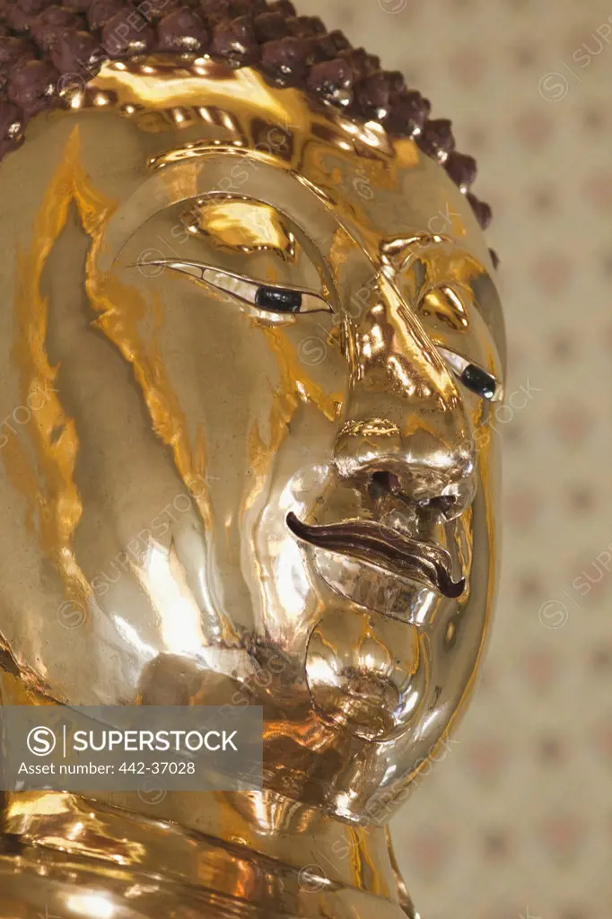 Close-up of the face of a golden statue of Buddha in Wat Traimit (also known as the Golden Buddha Temple), Bangkok, Thailand