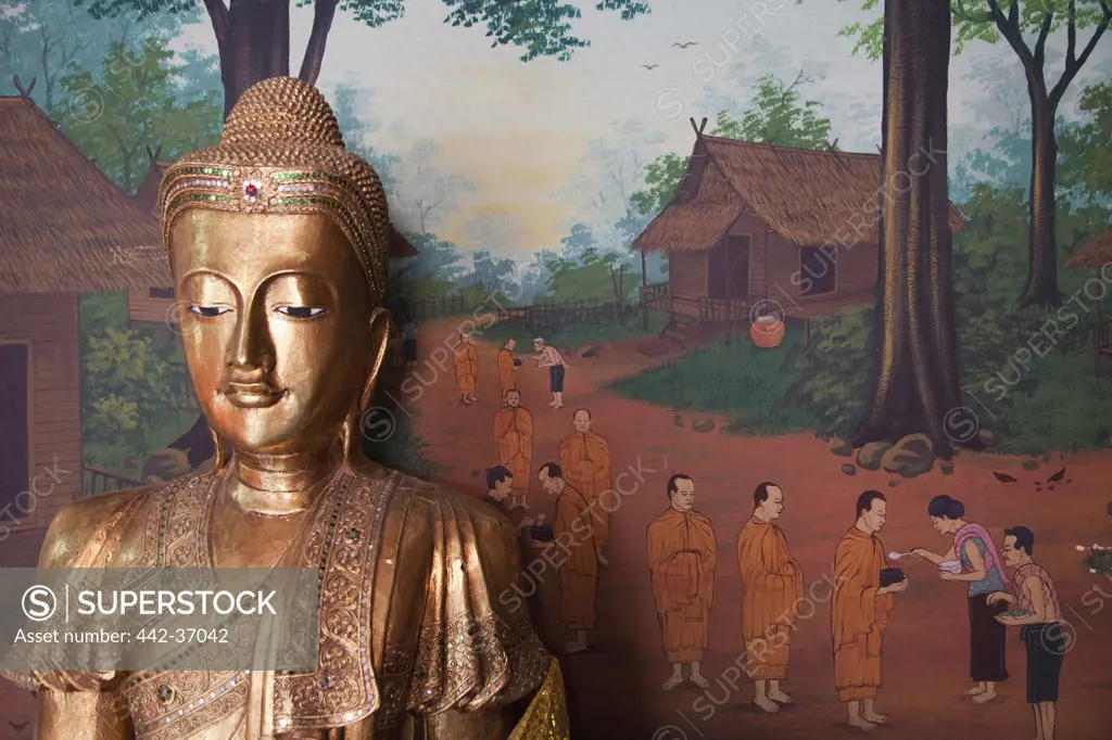 Buddha statue and wall art depicting village life in Wat Chana Songkhram, Khaosan Road, Bangkok, Thailand