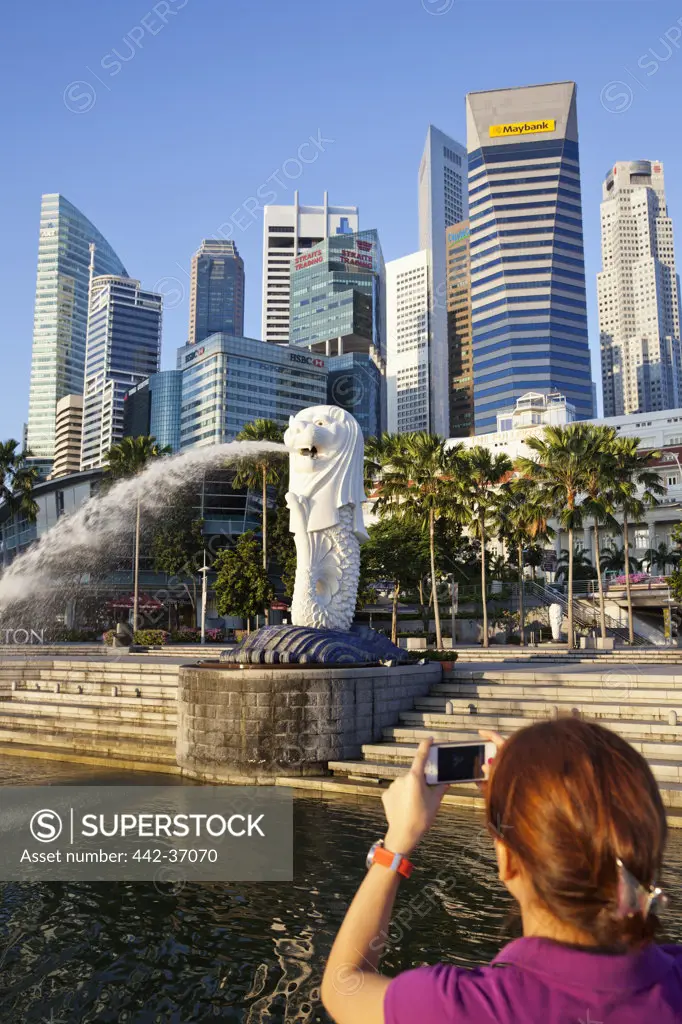 Woman taking picture of skylines, Merlion Statue, Marina Bay, Singapore City, Singapore